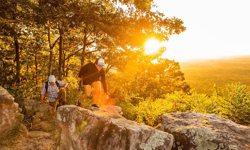 people hiking on a rock