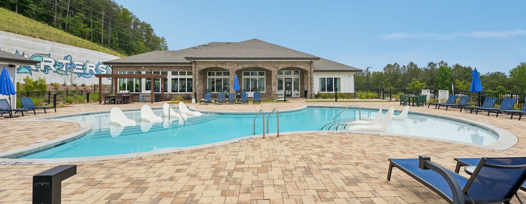 a swimming pool with lounge chairs and a building in the back